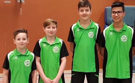 Vier Jungen in gr&uuml;nen Sporttrikots stehen nebeneinander in einer Sporthalle. Ihre Blicke sind direkt zur Kamera gerichtet.