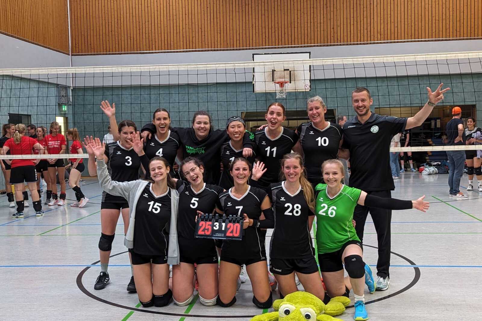 Volleyballmannschaft mit 11 Spielerinnen und Trainer feiert den Sieg, mit einem Punktestand von 25:20 auf dem Spielbrett.