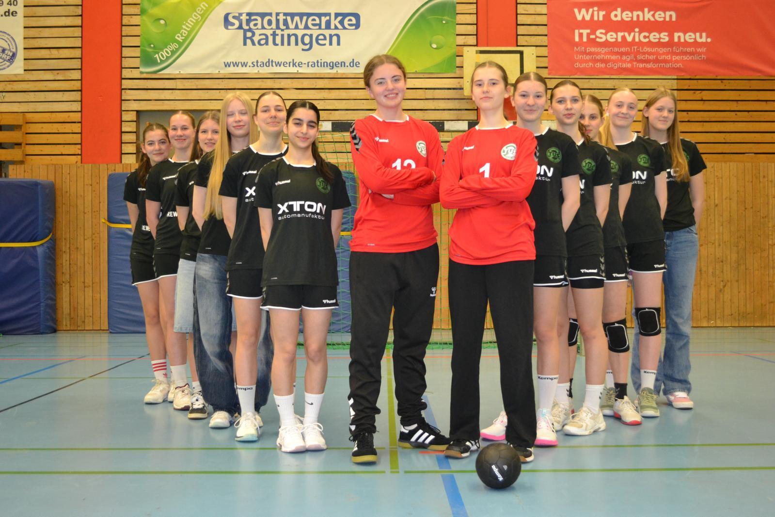 Gruppenfoto von zehn weiblichen Handballspielern in Sportkleidung, zwei Spielerinnen tragen Torwarttrikots.