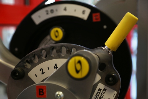 Nahaufnahme eines Ger&auml;ts mit Ziffernbl&auml;ttern und einem gelben Hebel f&uuml;r die Einstellung der Widerstandsst&auml;rke.