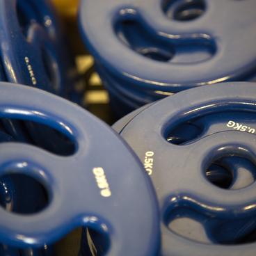 Blaue Gewichtsplatten stapeln sich, mit eingepr&auml;gtem Gewicht von 0,5 kg auf der Oberfl&auml;che.