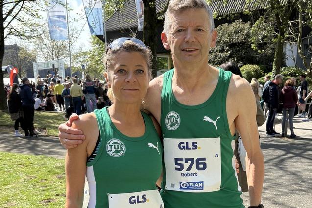 Zwei L&auml;ufer stehen l&auml;chelnd nebeneinander, gekleidet in gr&uuml;ne Trikots mit den Startnummern 575 und 576.