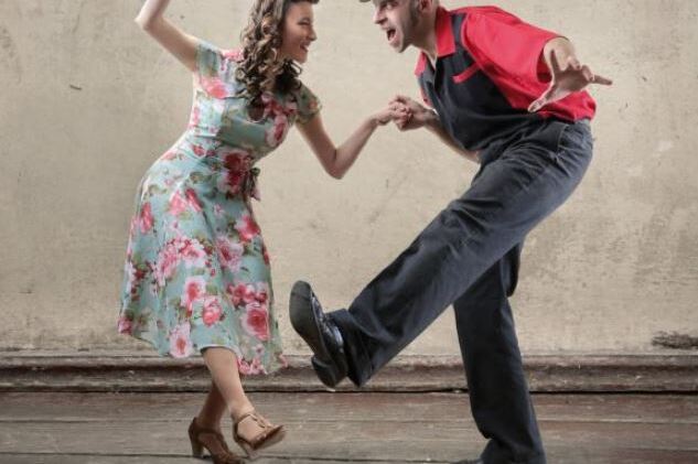 Paar tanzt Boogie Woogie in Freizeitkleidung mit Informationen zum kostenlosen Workshop am 10.11.2023.