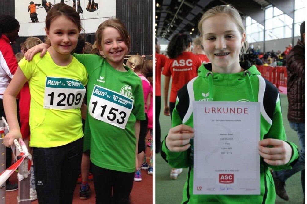 Zwei junge Läuferinnen mit Startnummern in Sportkleidung lächeln gemeinsam. Rechts hält eine von ihnen eine Urkunde.