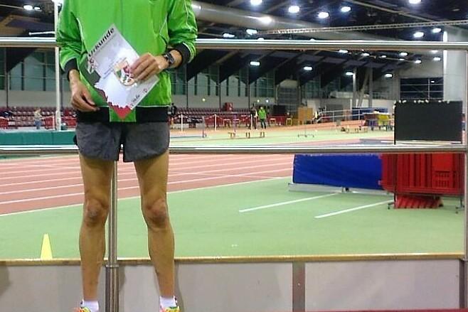Zwei Athleten stehen auf einem Siegerpodest in Sportanz&uuml;gen, der erste h&auml;lt ein Zertifikat in der Hand.