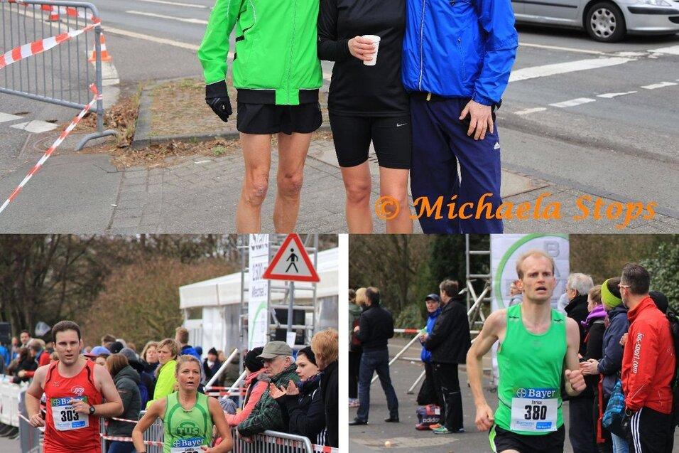 Drei Sportler stehen l&auml;chelnd am Stra&szlig;enrand, w&auml;hrend zwei L&auml;ufer in Wettkampfsituationen vorbeilaufen.