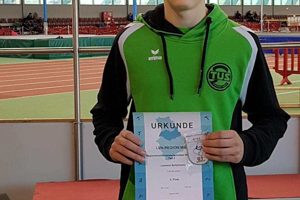 Junger Athlet in Sportbekleidung hält Urkunde und Medaille nach erfolgreich absolviertem Wettbewerb in einer Sporthalle.