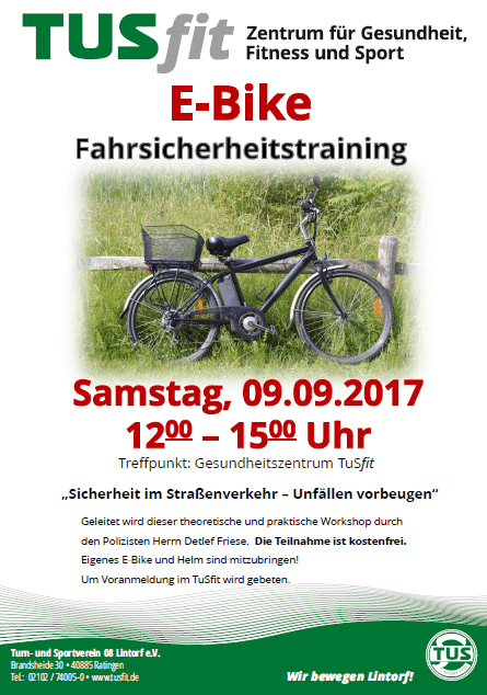 E-Bike steht auf einem Weg, umgeben von Wiese, mit Informationen über ein Fahrsicherheitstraining im Hintergrund.