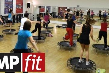 Gruppentraining auf Trampolinen in einem Fitnessstudio, mit mehreren Teilnehmern in Bewegung. Logo "JUMPfit" im Vordergrund.