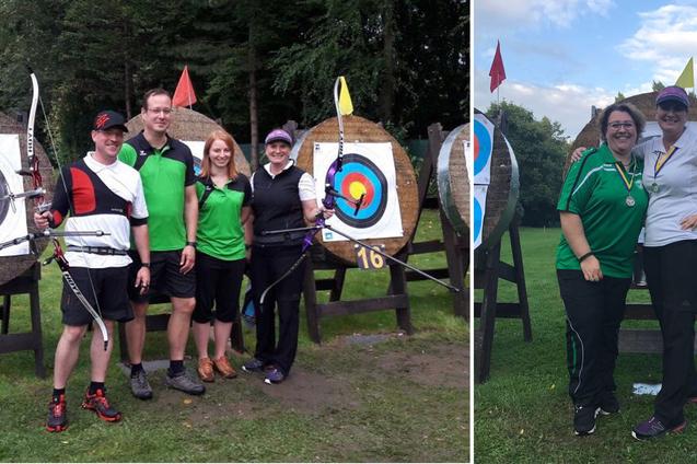 Gruppe von Bogensch&uuml;tzen steht vor Zielscheiben im Freien, drei Personen tragen B&ouml;gen, zwei sind mit Medaillen geschm&uuml;ckt.