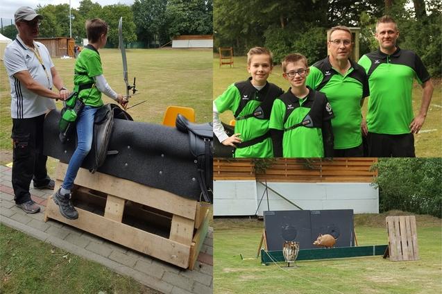 Kind sitzt auf einem Trainingssimulator mit einer Sportger&auml;t, umgeben von zwei Erwachsenen in gr&uuml;nen Shirts und einer Zielscheibe im Hintergrund.