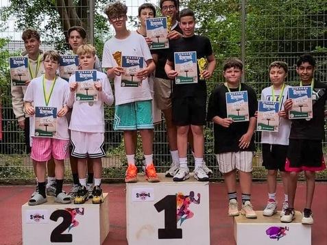 Gruppe von Jugendlichen auf dem Siegertreppchen mit Urkunden und Medaillen nach einem Tischtennisturnier.