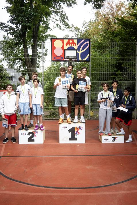 Gruppe junger Sportler auf Treppchen nach Wettkampf, mit Medaillen und Urkunden in den H&auml;nden.