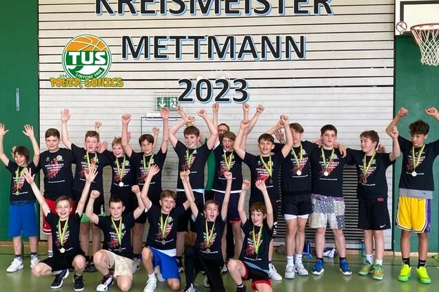 Gruppe von Jungen in Sportoutfits mit Medaillen feiert den Titel "Kreismeister Mettmann 2023".