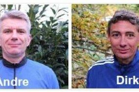Zwei M&auml;nner in blauen Sportjacken stehen vor gr&uuml;nen Pflanzen, beschriftet mit &bdquo;Andre&ldquo; und &bdquo;Dirk&ldquo;.