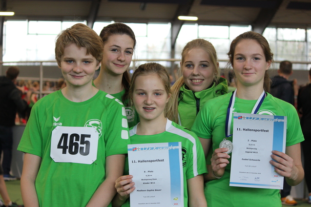 F&uuml;nf Sportlerinnen in gr&uuml;nen Trikots halten Urkunden und Medaille nach einem Hallensportfest.