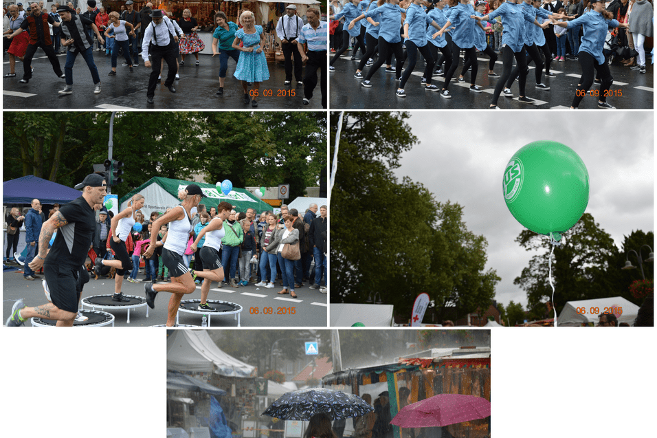 Menschen tanzen in Regenkleidung auf einem Festival, w&auml;hrend Besucher unter Regenschirmen zuschauen.
