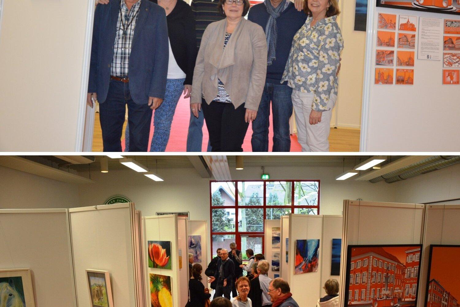 Gruppenfoto von sechs Personen vor Kunstwerken in einer Ausstellungshalle; im Hintergrund Besucher an weiteren Exponaten.