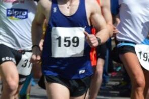 L&auml;ufer in blauer Sportbekleidung mit Startnummer 159, umgeben von weiteren Teilnehmern bei einem Rennen.