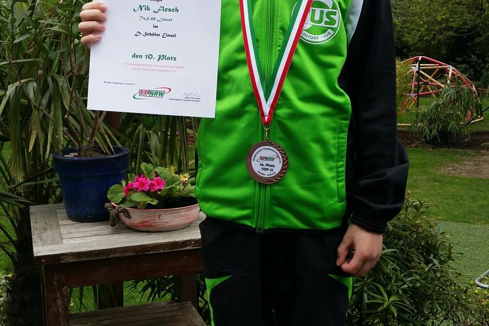 Junger Junge in Sportkleidung h&auml;lt eine Urkunde und Medaille in einem Garten mit Pflanzen und Holzterrasse.