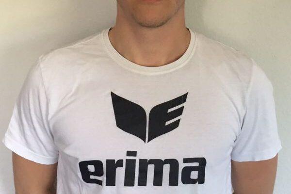 Junger Mann mit Kappe und T-Shirt mit dem Aufdruck &bdquo;erima&ldquo; vor einem wei&szlig;en Hintergrund.