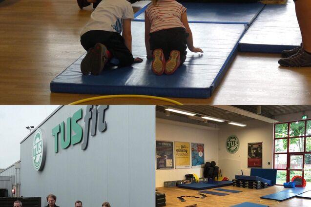 Kinder beobachten eine Frau auf einer Matte, w&auml;hrend im Hintergrund ein Fitnessbereich mit Equipment zu sehen ist.